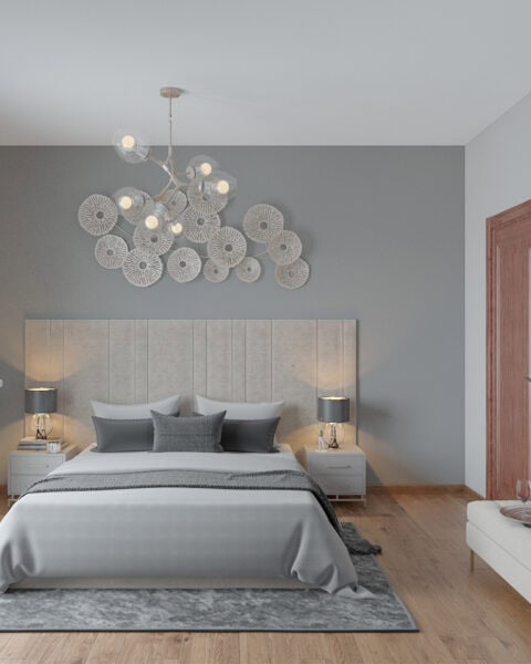 Modern bedroom with gray accent wall, upholstered headboard, two nightstands with lamps, and decorative circular wall art above the bed; calm neutral palette.（informative）?